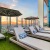 umbrella shaded lounge chairs on pool deck