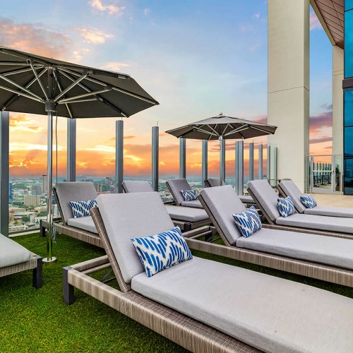 Poolside umbrella shaded lounge chairs on pool deck
